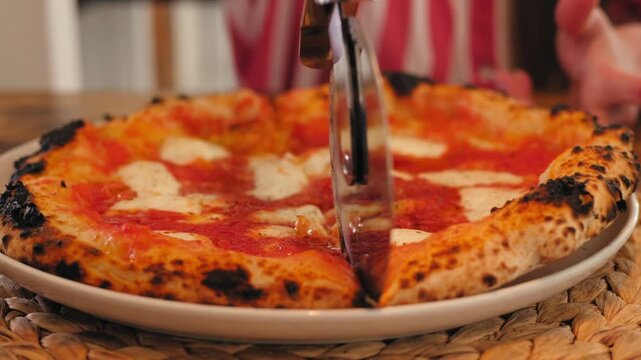 Cooking italian pizza, neapolitan Margherita pizza with mozzarella cheese, tomato sauce, olive oil and basil leaves.