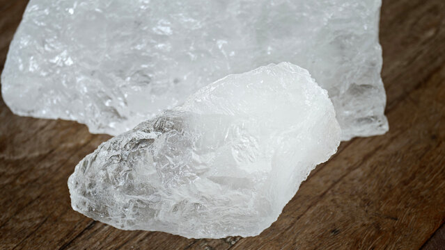 A clear block of alum placed on the wooden floor.