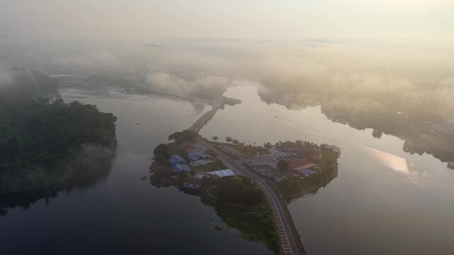 Fog blankets the small island. Bridge connects it to the mainland at Tasik Raban