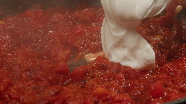 Cooking tomato sauce close-up. Classic homemade Italian tomato sauce for pasta and pizza in the pan. Chef cooking traditional Italian food.