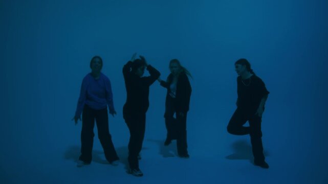Dancer class Professional choreographer dancing with backup dance on color changing neon in studio for dance video clip. Four women dancers showing hip hop movements. Advertising of dance school.