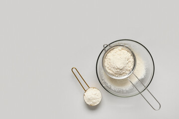 Obraz premium Baking and culinary preparation, wheat flour in a sieve and measuring cup for cooking recipes and homemade food production on a neutral background