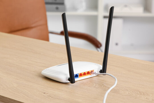 Internet connectivity and network infrastructure, wireless router with ethernet cable on office desk for high speed broadband and digital communication