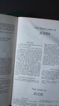 Opening to the book of 3 John, of the New Testament in the Holy Bible. New Revised Standard Version. Vertical video.
