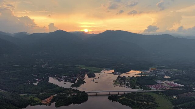 Aerial view captures golden sunset over mountain range at Tasik Raban