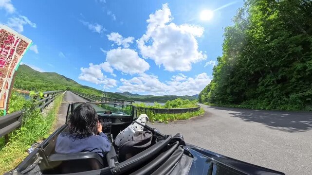 Classic convertible driving on a quiet rural road in Japan