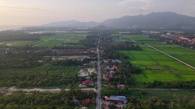 Aerial view of a peaceful rural landscape featuring farmland, scattered houses, a central road at Balik Pulau, Penang