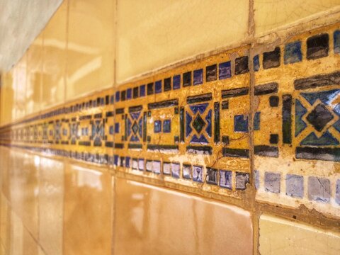 Moroccan wall tiles featuring golden yellow ceramic and blue geometric patterns, suitable for architectural design projects and interior decoration.