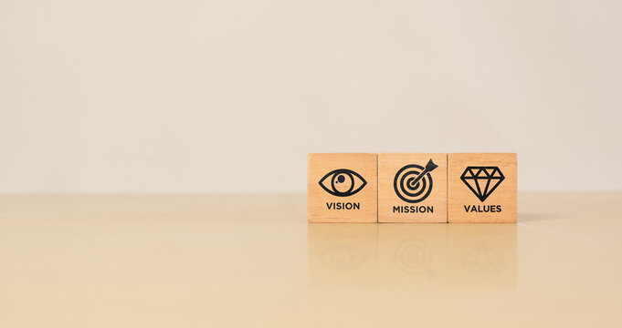 Mission, vision and values of company. Purpose business concept. Wooden cube with mission vision and values symbols on grey background. Modern vertical design. Business presentation