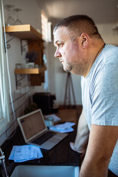 Concerned man managing finances at kitchen counter