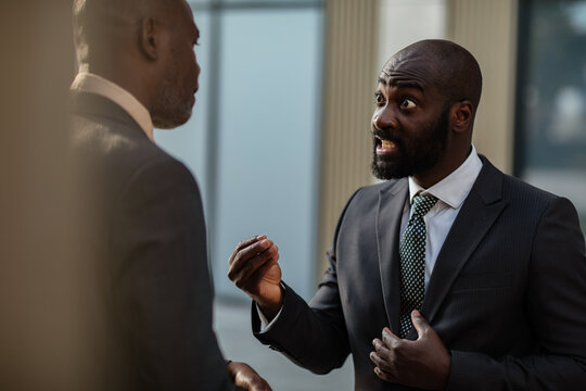 Two businessmen arguing outside office building