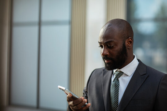 Business executive using smartphone outside office building