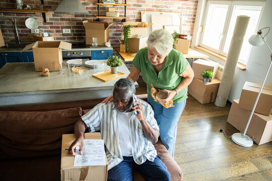 Senior couple unpacking boxes in new home kitchen