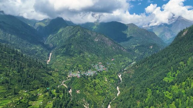 Aerial pullback shot highlighting the extreme topography and isolation of Tosh village, a renowned summer trekking basecamp in Kullu.