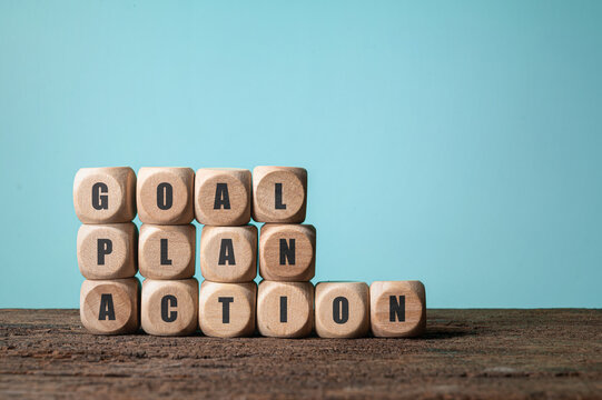Wooden Blocks with Words Goal Plan Action on Blue Background