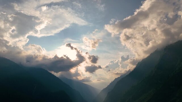 Wide aerial view capturing dramatic monsoon clouds and sunbeams over Tosh, Barshaini village, Kheerganga trekking and camping basecamp in the Himalayas.
