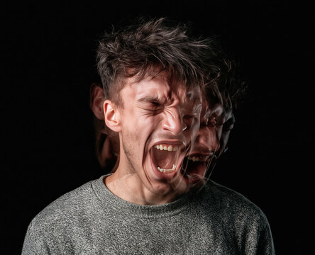 Screaming man in agony with motion blur double exposure effect shouting in fury and despair against dark background