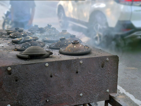 Atmospheric Scene at a Traditional Indonesian Street Food Vendor with Dense Smoke Rising Around the Clay Stove Cooking Surabi Pancakes