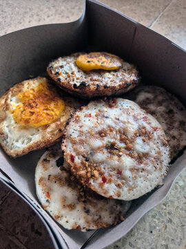 Traditional Indonesian Surabi Rice Flour Pancakes Topped with Savory Oncom and Egg Arranged Neatly Inside a Paper Meal Box