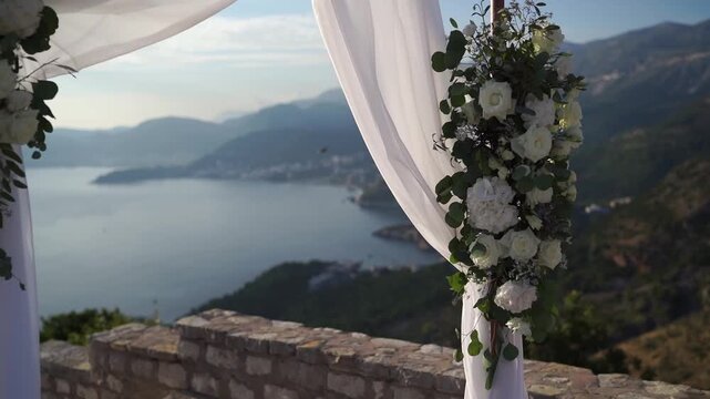 Wedding floral arch with white roses overlooking Bay of Kotor from mountain terrace