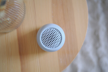 Obraz premium Small speaker on wooden table with glass nearby
