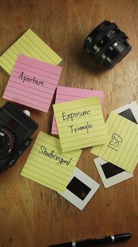 Video of hand with notes about Exposure Triangle in photography Shutter Speed, Aperture and ISO
