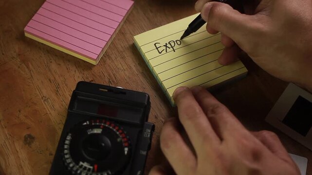 Video of hand with notes about Exposure Triangle in photography Shutter Speed, Aperture and ISO