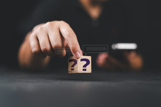Businessman using question marks with speech bubbles.Q and A. Online service gives quick answers. FAQ concept.