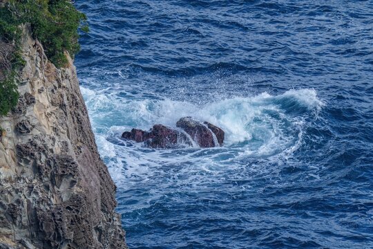 岩礁に打ち寄せる激しい白波と断崖絶壁の海岸風景
