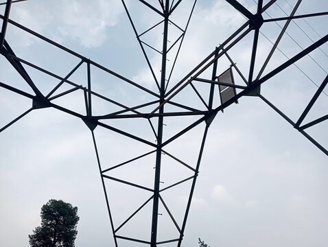 A bottom-up view shows the magnificent structure of the SUTT or SUTET steel electricity transmission tower against the sky background, showcasing the sturdy civil engineering construction details for 