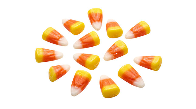 Scattered candy corn candies on a black isolated on png transparent background
