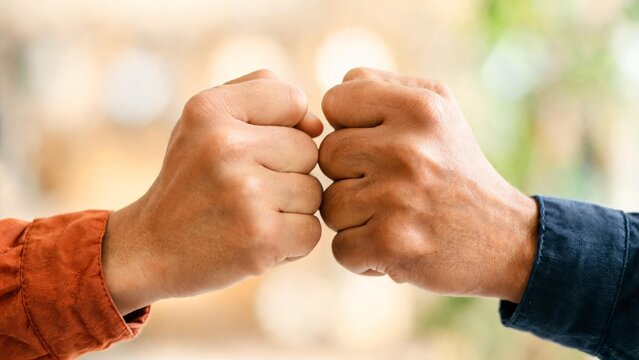 Two hands bumping fists in close-up showing teamwork and partnership concept