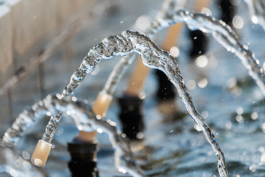 Splashes and jets of water against light background.