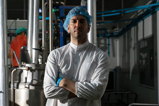Portrait Of Food scientist Worker In White Coat And Blue Cap in food factory.      