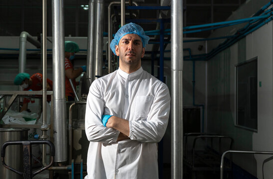Portrait Of Food scientist Worker In White Coat And Blue Cap in food factory.      