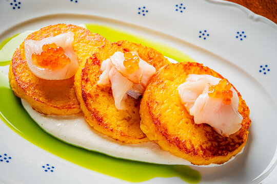 Gourmet delight of corn cakes topped with seafood and caviar on a beautiful plate