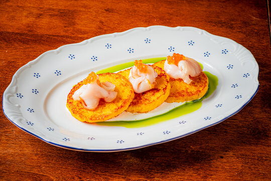 Delightful trio of savory plantain cakes topped with fresh seafood and vibrant sauce