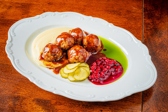 Delicious meatballs served on a rustic wooden table with vibrant sides