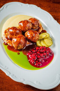 Savory meatballs served with creamy mashed potatoes and vibrant berry sauce