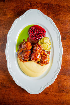 Delicious plate of savory meatballs served with creamy mashed potatoes and tangy garnishes