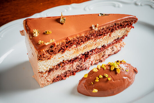 Delicious chocolate cake slice garnished with gold flakes and creamy chocolate mousse