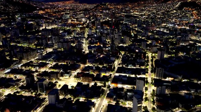 Aerial Night View of Quito Ecuador Downtown with Illuminated Streets, High Rise Buildings, Urban Grid and Mountain Capital Cityscape