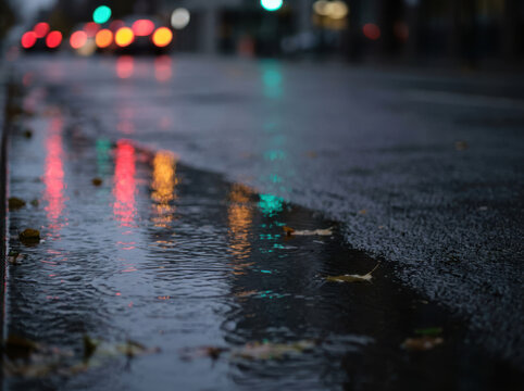 Traffic light reflection puddle rain street asphalt wet Road with glowing signals mirrored in puddle on wet asphalt at moody rainy night