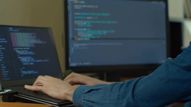 Web Developer Coding HTML On Computer Screens In Modern Office
