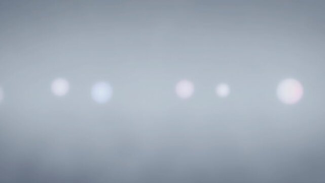 Blurred white light orbs in a row on a soft gray background