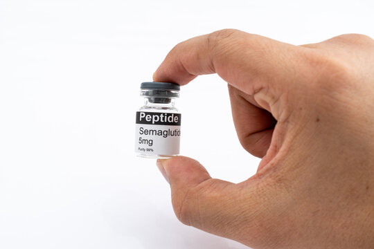 Hand holding Semaglutide peptide vial for research