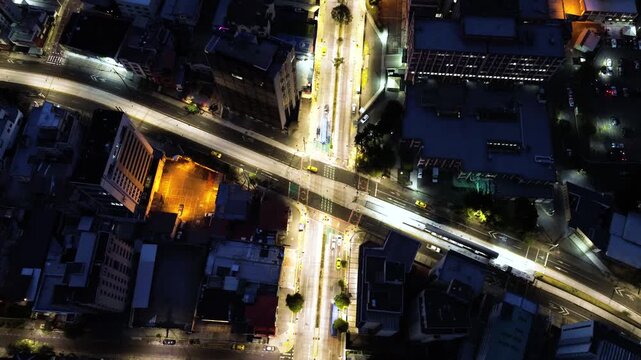 Top Down Drone View of Quito Ecuador Avenue at Night with Illuminated Roads, Crosswalks, Buildings and Urban Traffic Infrastructure