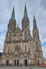 Fototapeta premium Front facade of the neo-Gothic Saint Wenceslaus Cathedral with high spires under a cloudy day sky in Olomouc, Czech Republic.