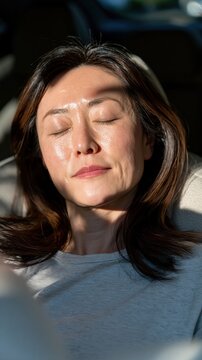 A woman sleeping in a modern car interior with the sunlight on her face, it is travel lifestyle visual emphasizing comfort and relaxation.