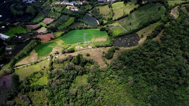 Drone View of Patchwork Farms and Forest Edge in Ecuador Mountain Valley, Rural Fields, Green Hills and Scenic Andean Countryside